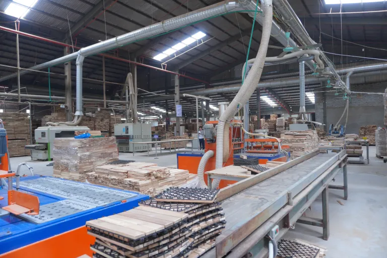 Conveyor carrying assembled decking tiles