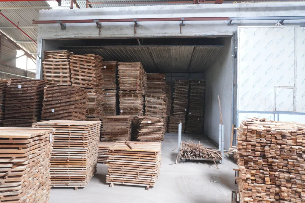 Lò sấy đang mở, chứa đầy gỗ xếp chồng