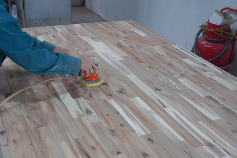 Orbital sander on the surface of a finger-jointed panel