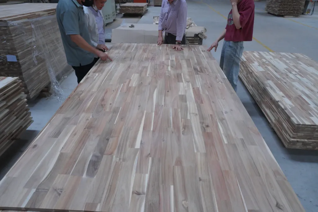 Team inspecting a finger-jointed acacia panel