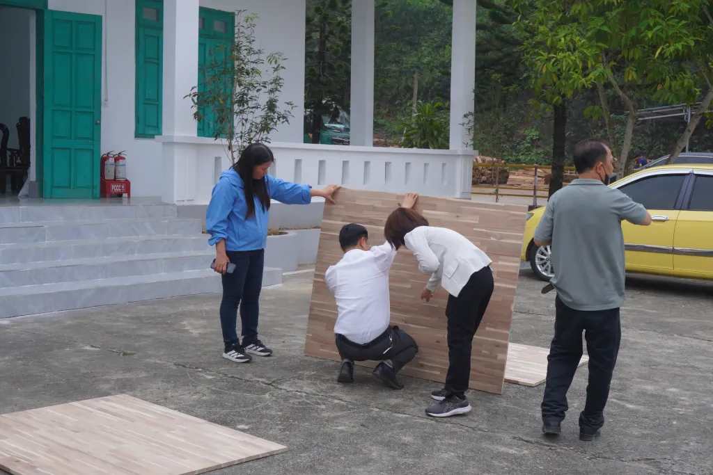 Group reviewing an acacia panel sample outside the office building