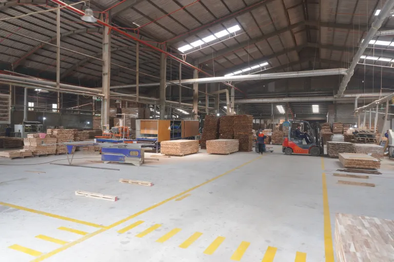 Wide production hall with marked walkways and a forklift