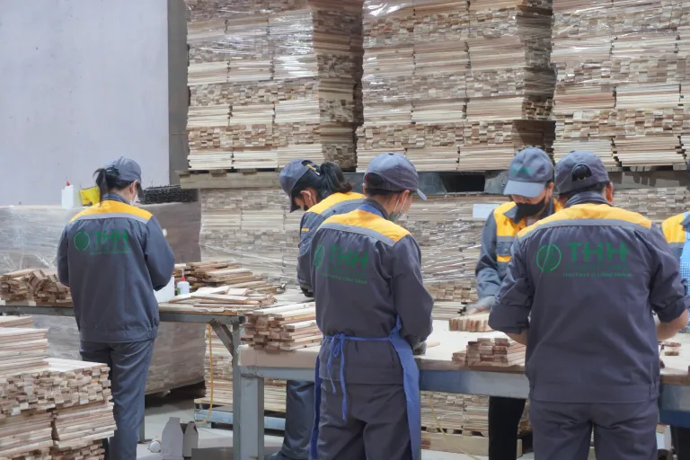 Workers in company uniforms at a grading table
