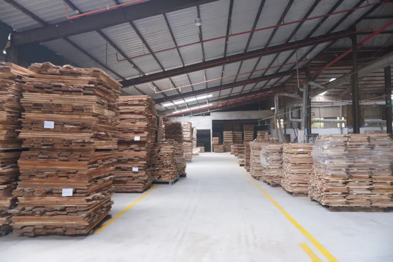 Warehouse aisle with yellow floor markings between timber stacks