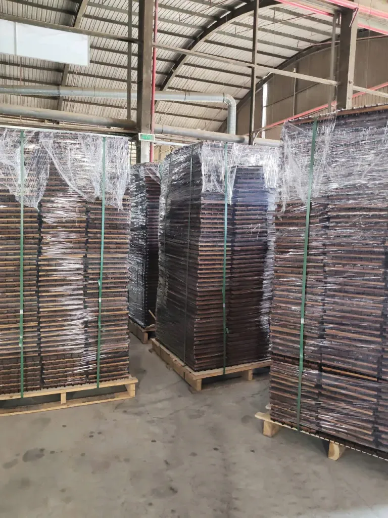 Pallets of stretch-wrapped decking tiles in the warehouse